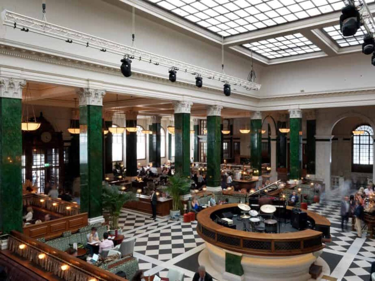 Banking hall with tall veined columns and long counters in use as bars