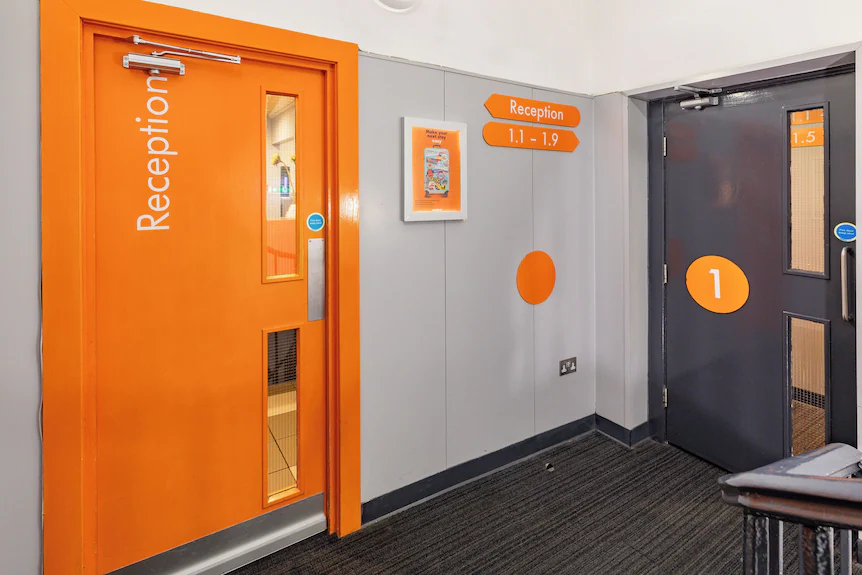 Small standardised hotel room with a fitted bed and a shower door