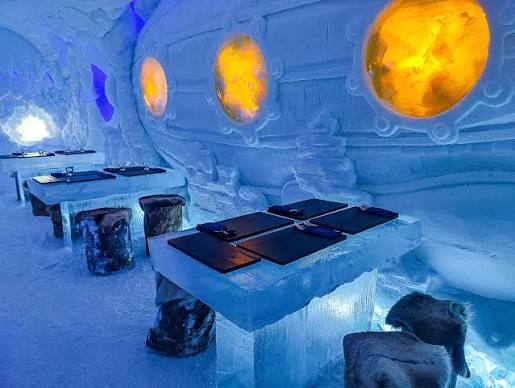 Ice bar counter lit from within, with carved seating cut from snow